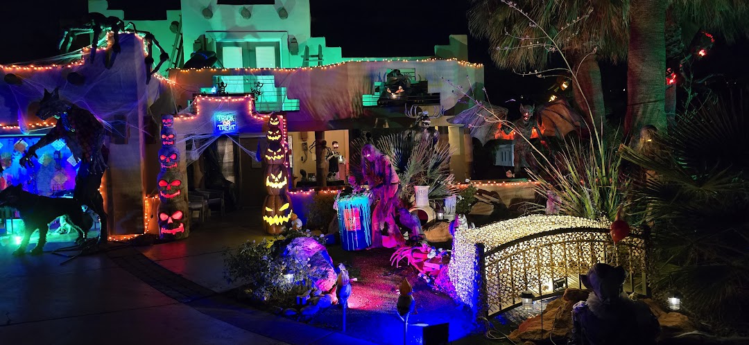 The Mays house Halloween display at night, lit up with glowing pumpkins and figures